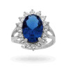 ANELLO SOLITARIO A GRIFFE CON ZIRCONE OVALE BLU ZAFFIRO CONTORNATO CON ZIRCONI BIANCHI IN ARGENTO 925 RODIATO