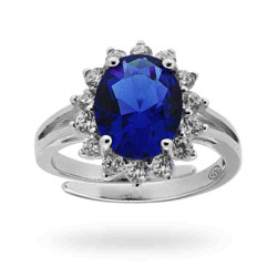 ANELLO SOLITARIO A GRIFFE CON ZIRCONE OVALE BLU ZAFFIRO CONTORNATO CON ZIRCONI BIANCHI IN ARGENTO 925 RODIATO
